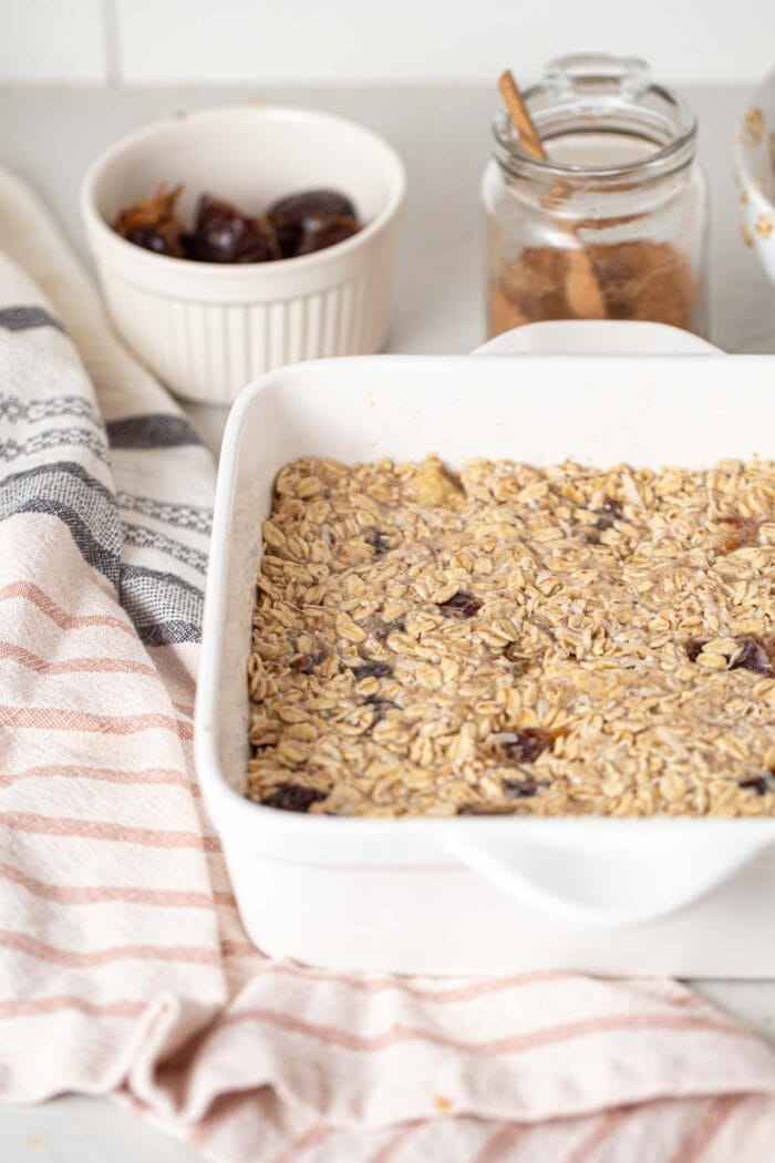 Raw oatmeal dough with banana and dates in a baking pan.