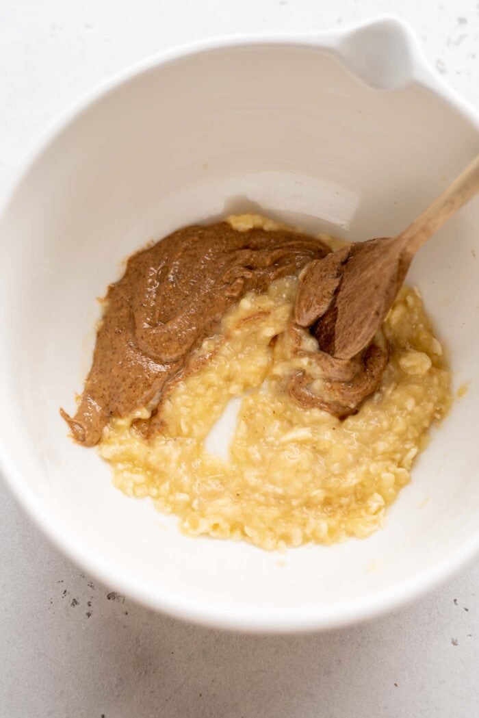 Mashed banana with almond butter in a mixing bowl.