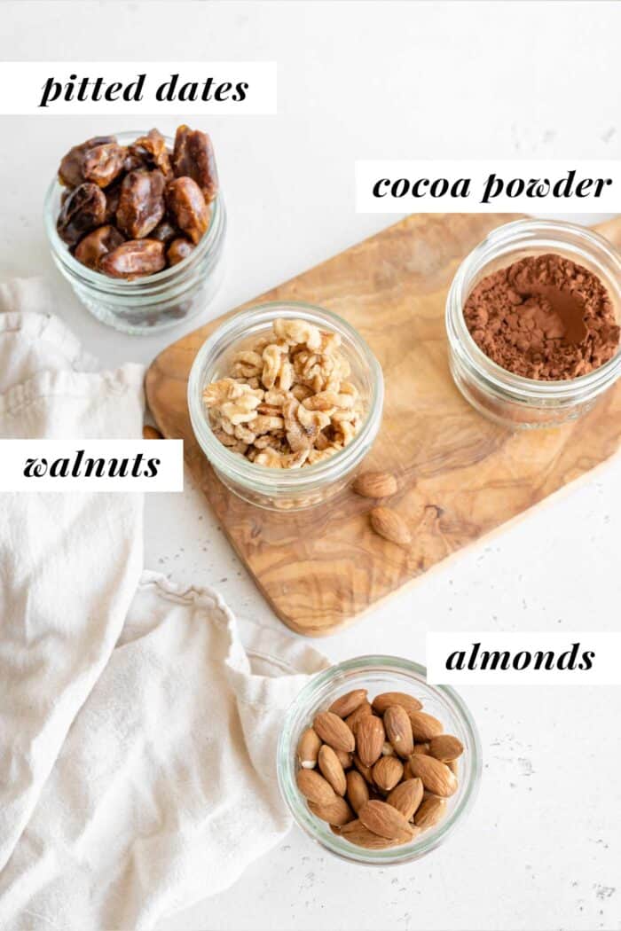 Dates, walnuts, almonds and cocoa powder in jars.