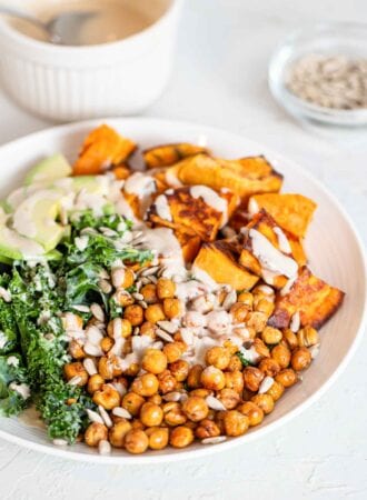 A kale, roasted chickpea, sweet potato and avocado salad in a bowl.
