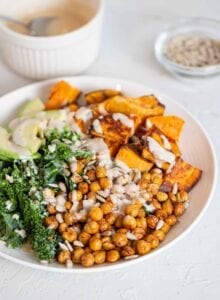 A kale, roasted chickpea, sweet potato and avocado salad in a bowl.