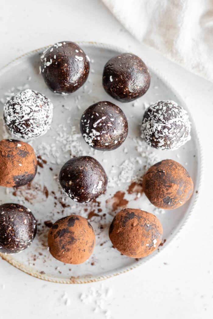 A plate of brownie balls rolled in cocoa powder and coconut.