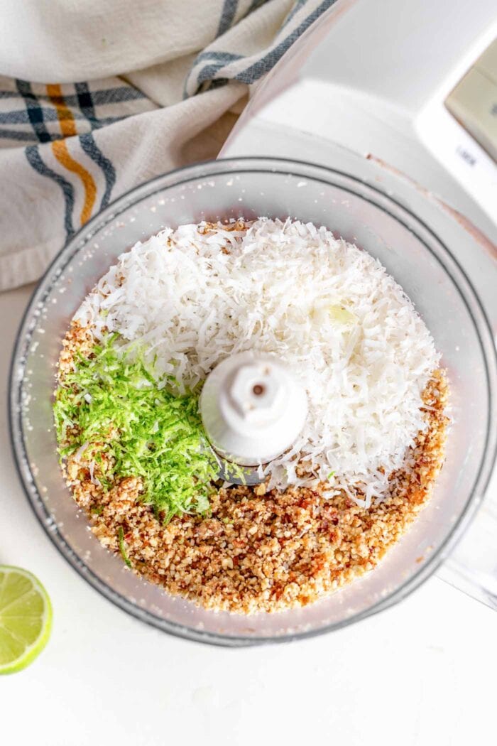 Crumbly dough with coconut and lime in food processor.