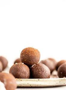 A stack of chocolate energy balls on a plate.