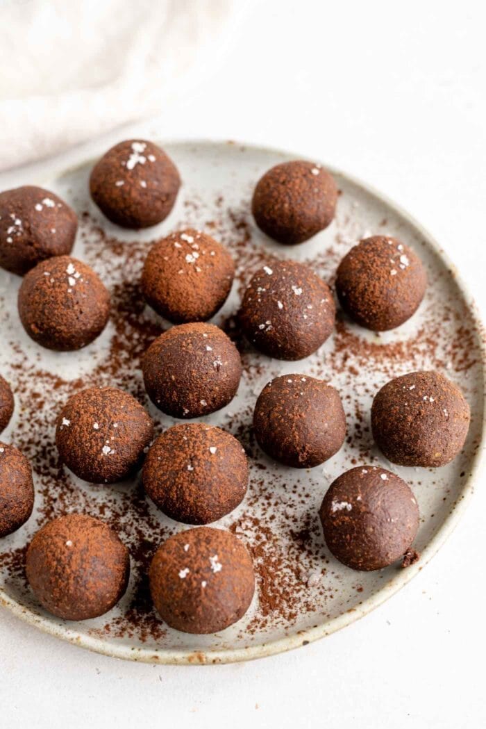 A plate of raw chocolate energy balls sprinkled with chocolate.