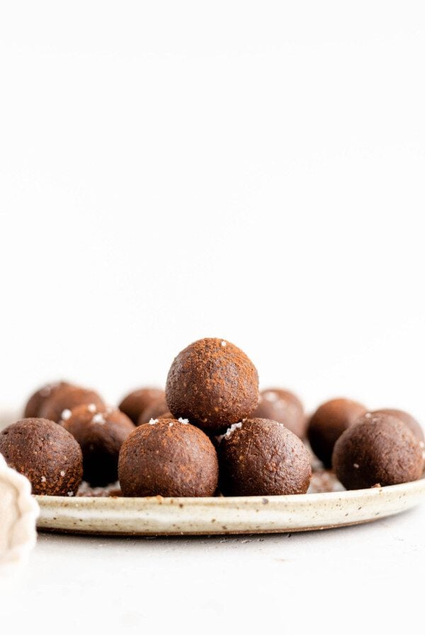 A stack of chocolate energy balls on a plate.