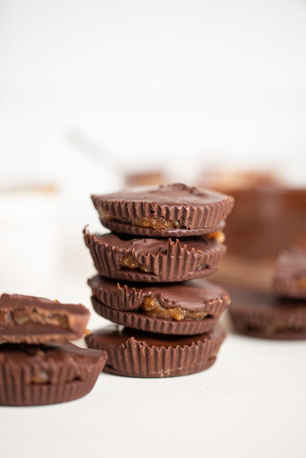 A stack of chocolate cups with caramel inside them.