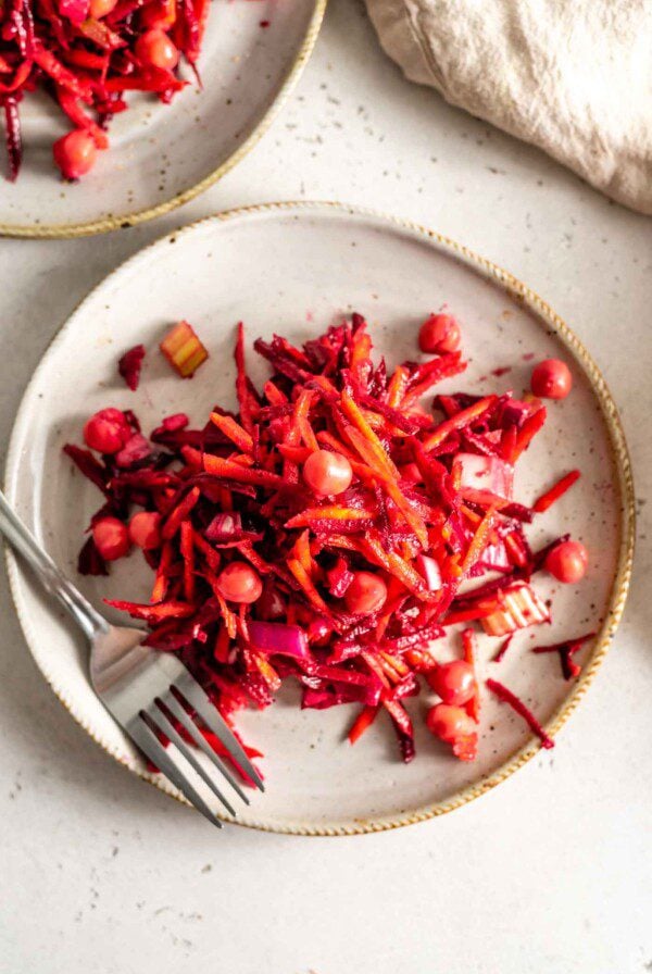 Beet, carrot and chickpea salad on a plate with a fork.