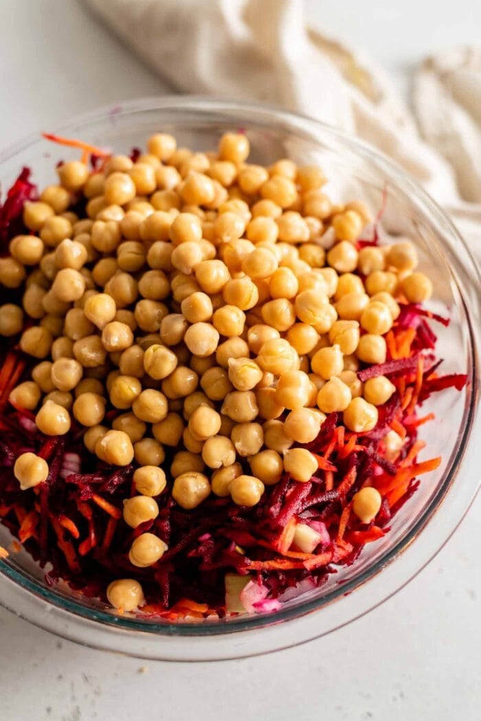 Chickpeas and beets in a glass mixing bowl.
