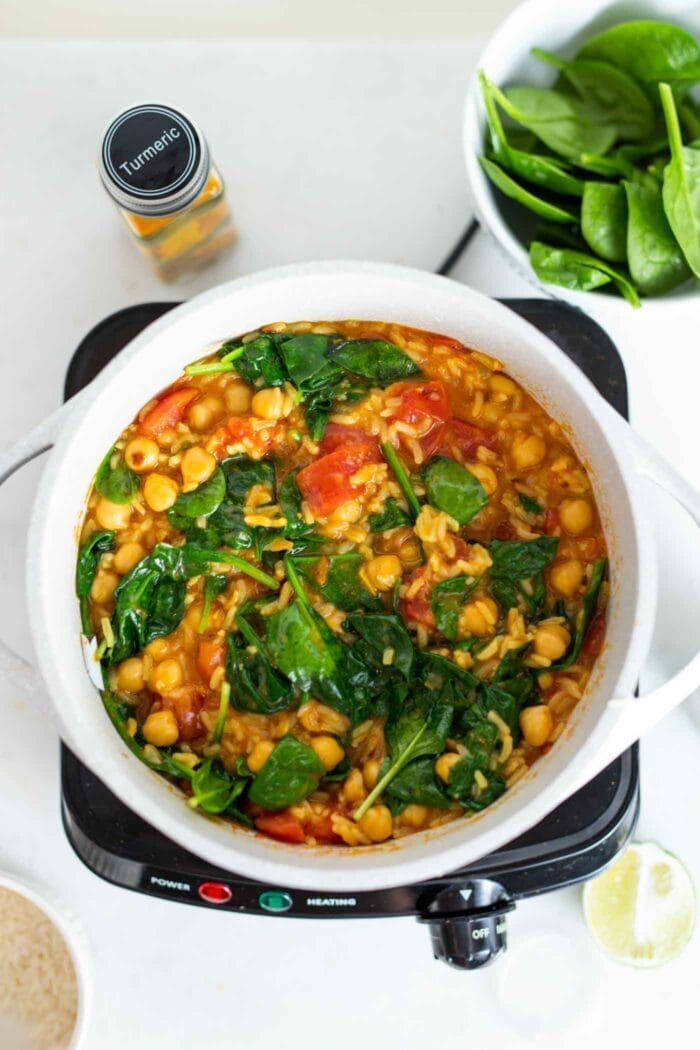 A pot of chickpea and rice stew with spinach.