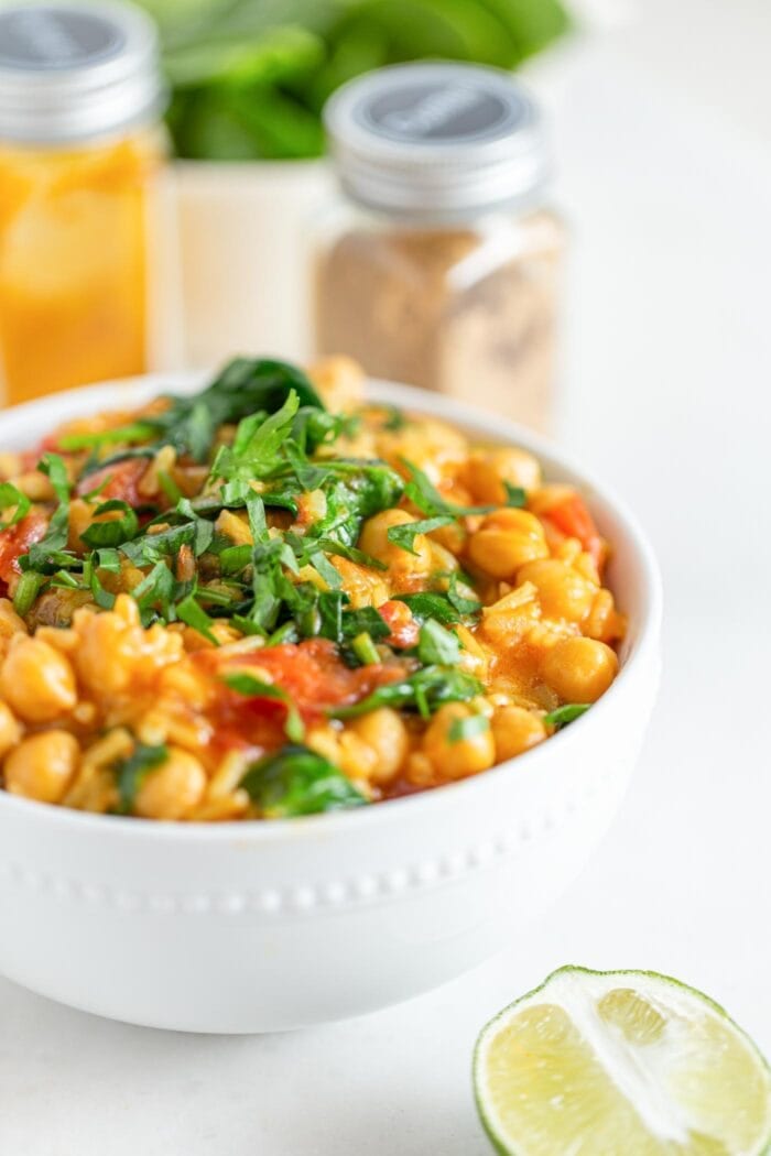A close up of a bowl of chickpea rice stew topped with fresh cilantro.