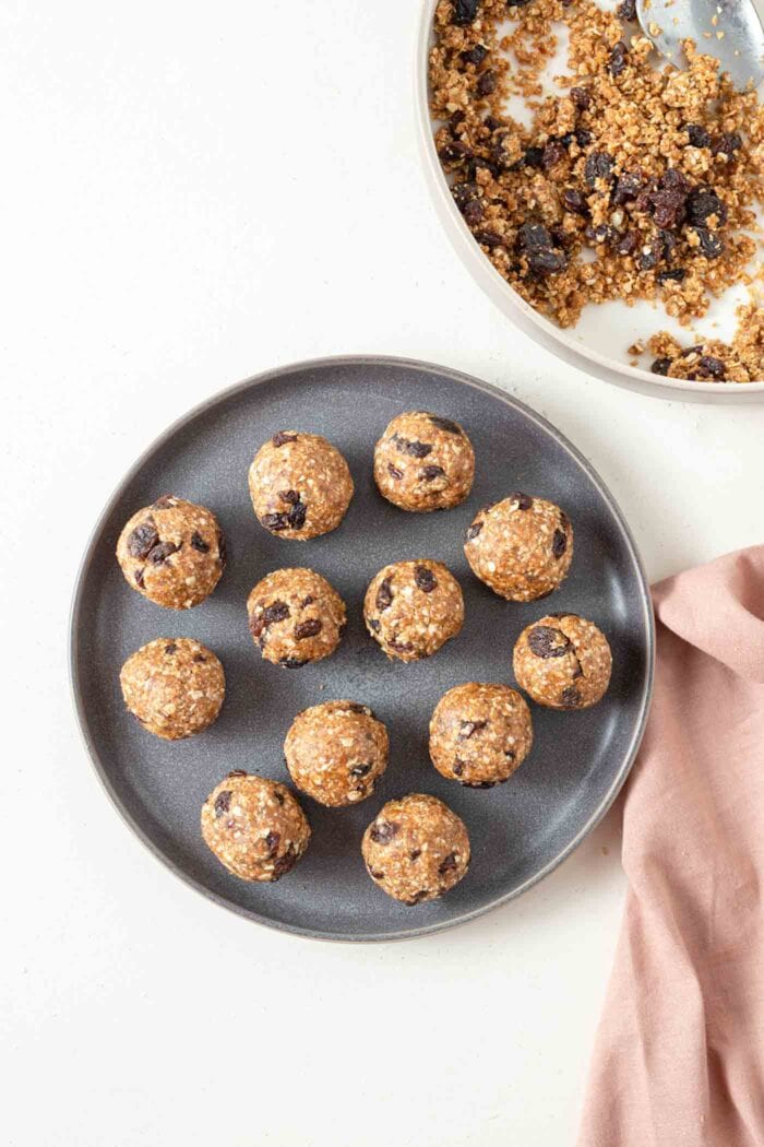 A number of no-bake cookie dough balls with raisins on a plate.