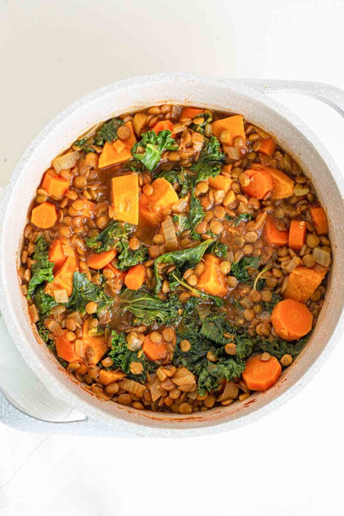 A sweet potato, carrot, lentil stew in a large soup pot.