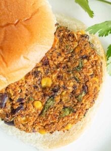 A close up of a veggie burger patty on a bun.