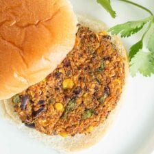 A close up of a veggie burger patty on a bun.