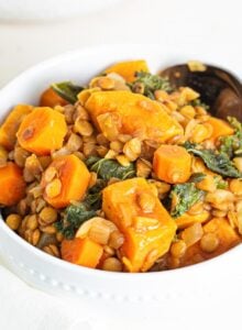 A bowl of sweet potato lentil stew with kale mixed into it.