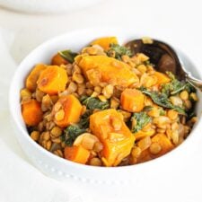 A bowl of sweet potato lentil stew with kale mixed into it.