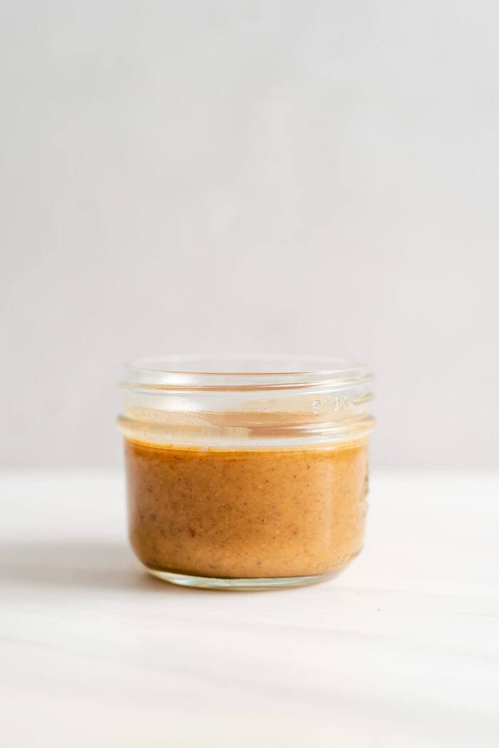A small jar of creamy almond butter sauce.