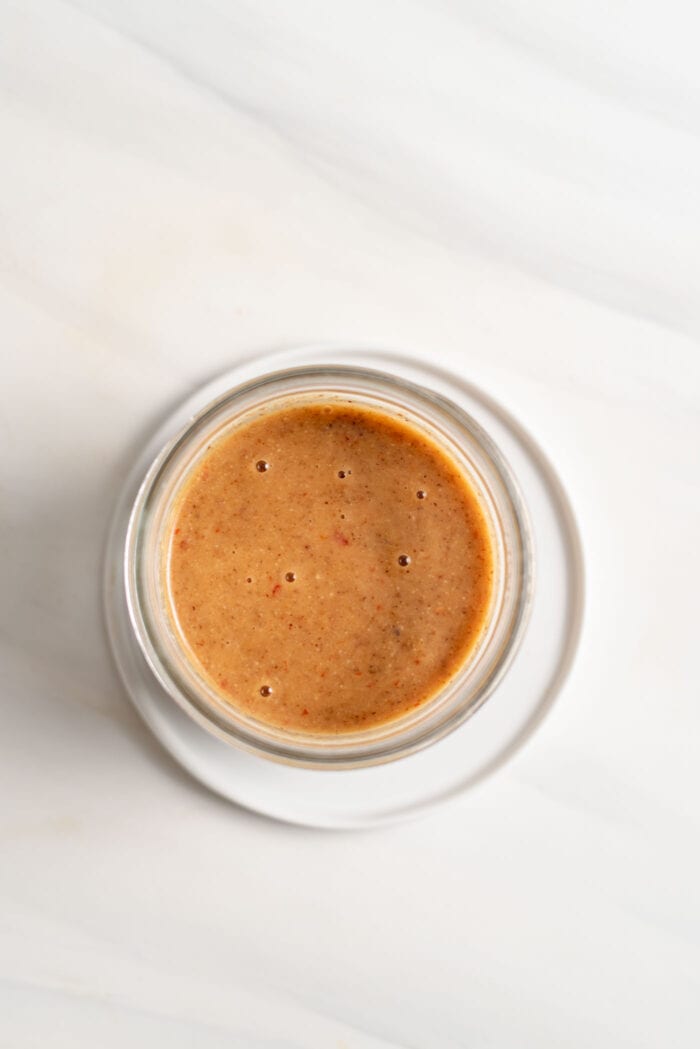 Overhead image of a creamy sauce in a jar.