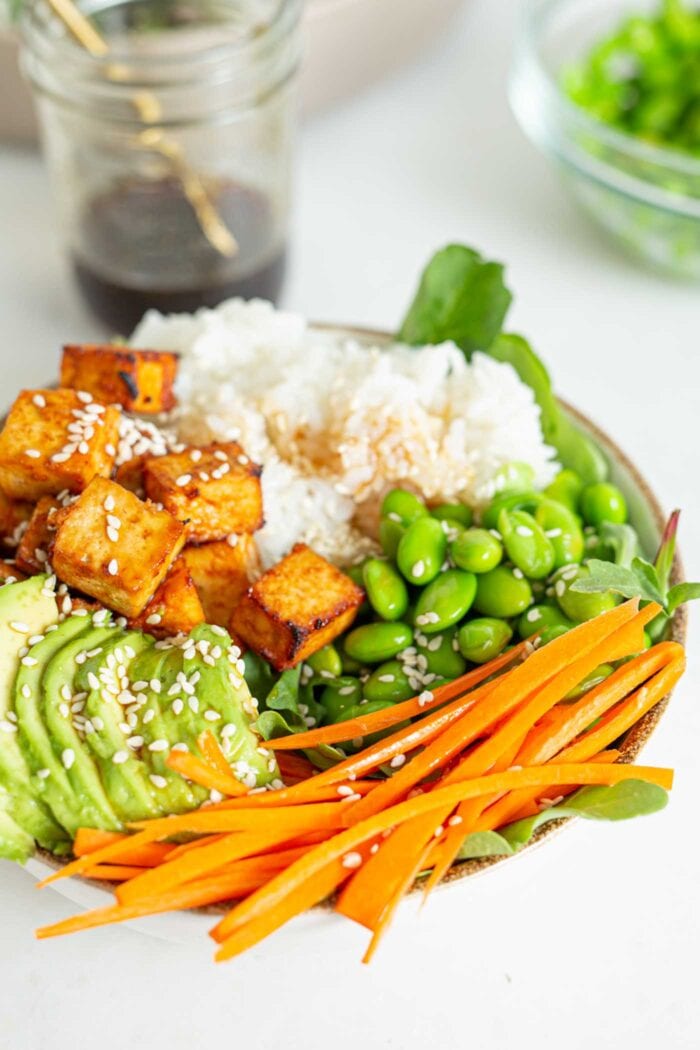 Crisp baked tofu in a bowl with avocado, rice and edamame.