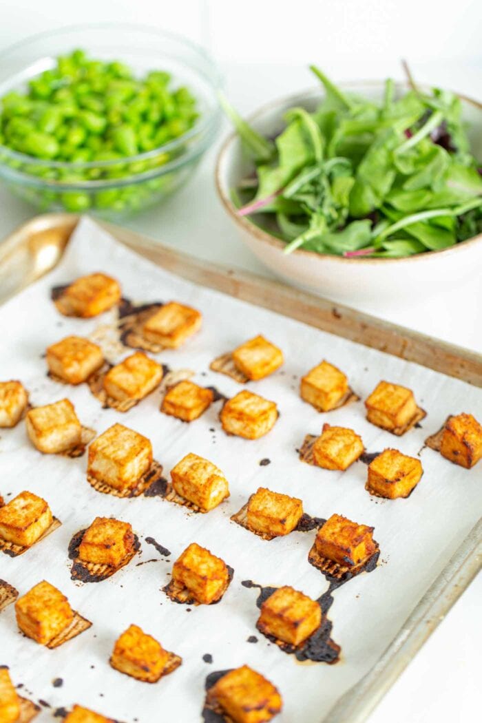 Baked tofu on a baking sheet with parchment paper.