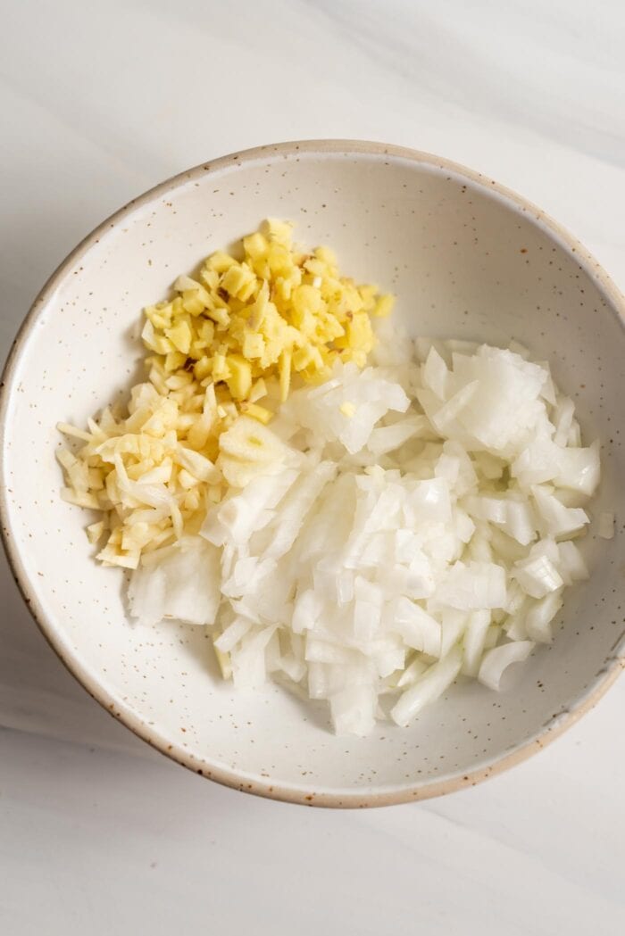 Chopped onions, ginger and garlic in a small bowl.