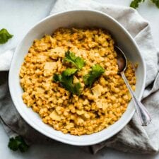 A bowl of red lentil dahl topped with fresh cilantro.