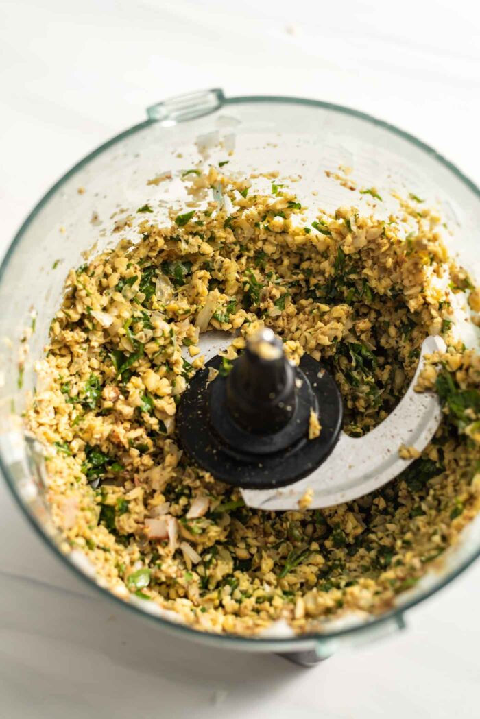 Blended chickpea and herb mixture in a food processor.