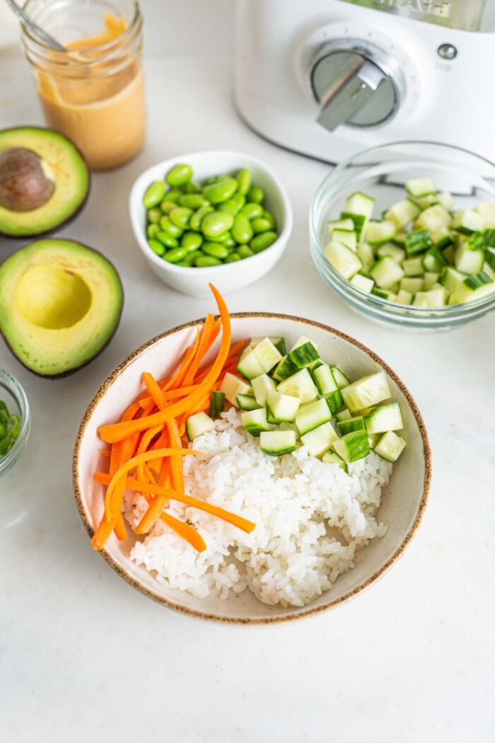 Rice, carrot and diced cucumber in a bowl.