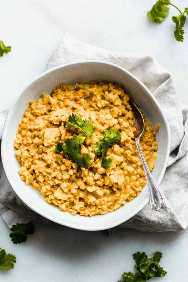 A bowl of red lentil dahl topped with fresh cilantro.