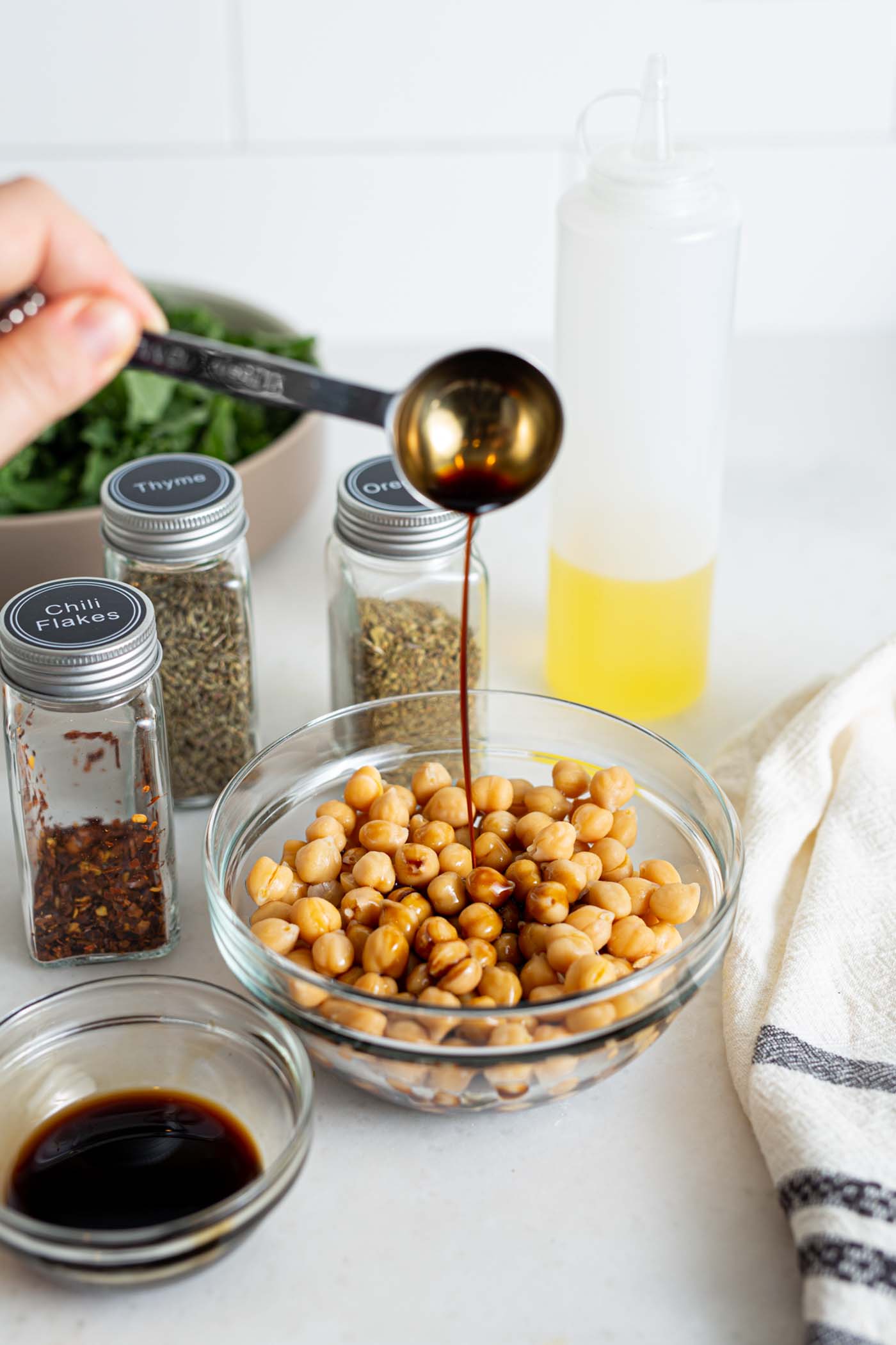 Pouring balsamic vinegar into a bowl of chickpeas.