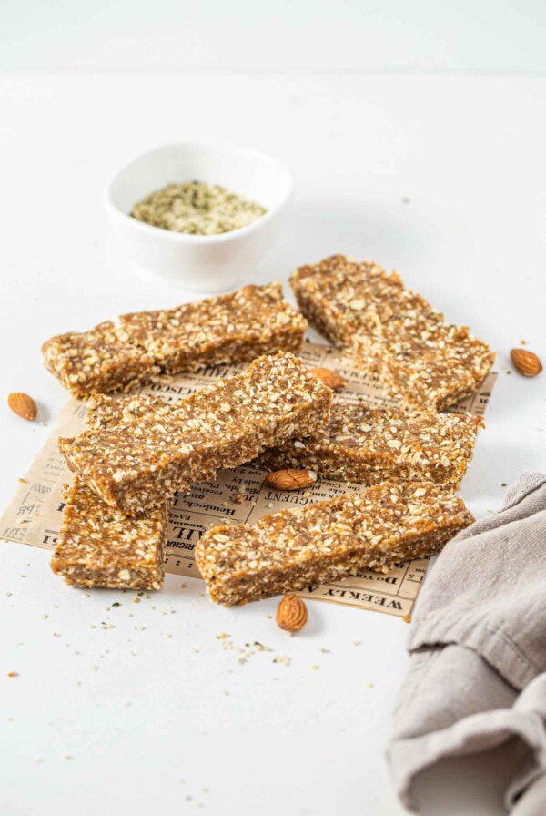 A pile of energy bars on a kitchen counter with a dish cloth beside them.