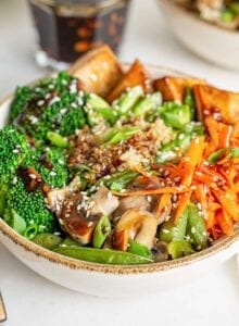 A colorful teriyaki quinoa and tofu bowl with carrot, broccoli and avocado.