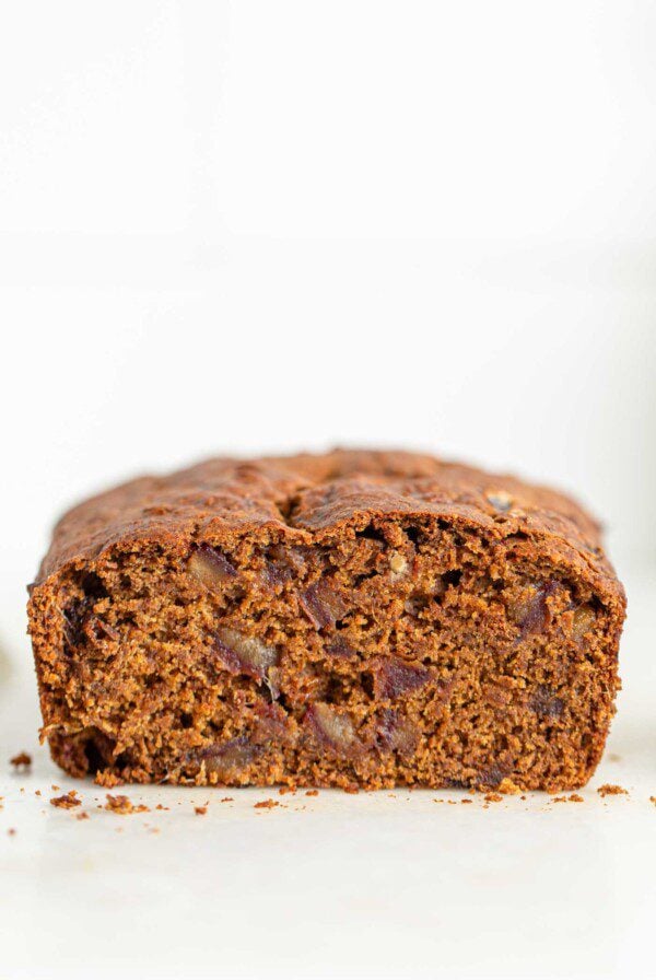 Cut open loaf of pumpkin bread with dates in it.