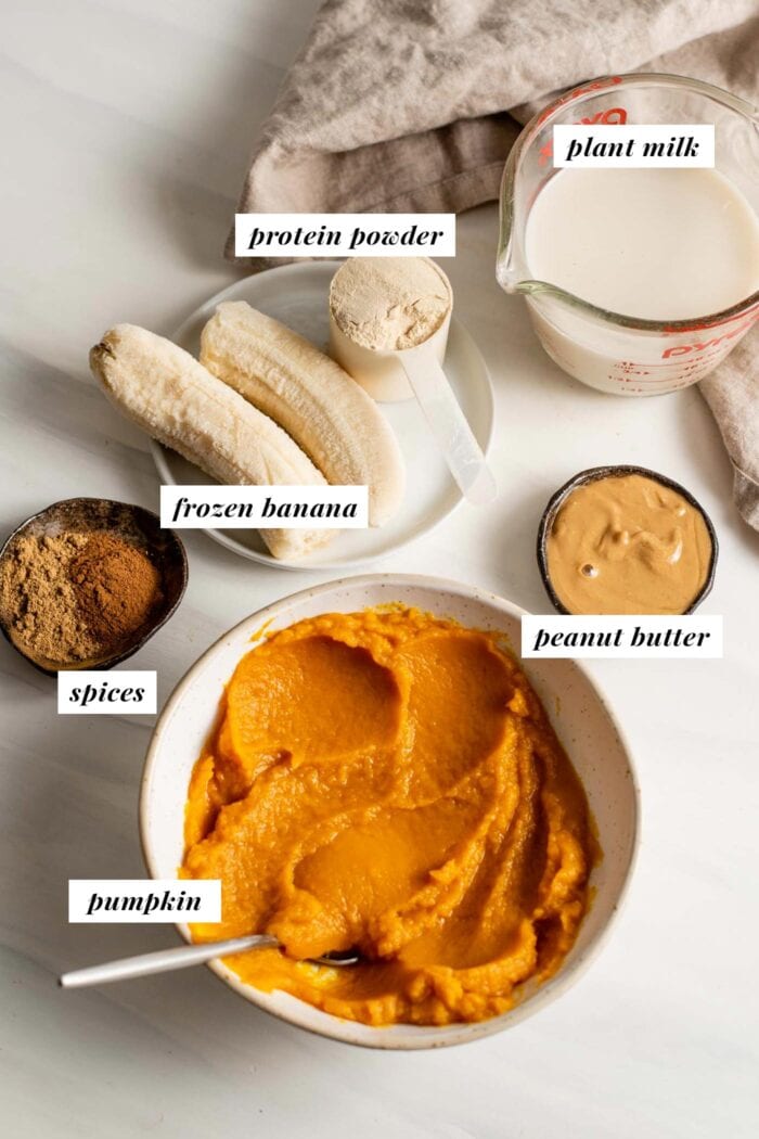 Labelled ingredients in bowls for making a pumpkin and peanut butter smoothie.
