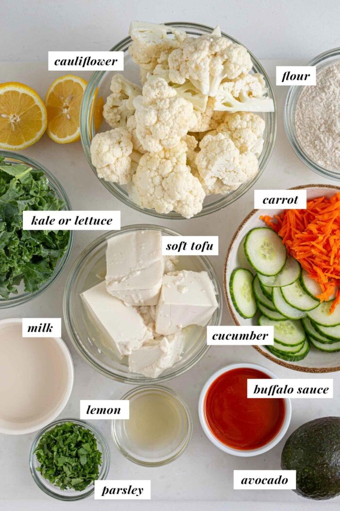 Labelled ingredients for making a buffalo cauliflower wrap with avocado, kale, cucumber and carrot.