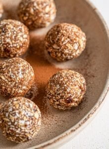 Plate of oatmeal energy balls sprinkled with cinnamon.