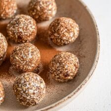 Plate of oatmeal energy balls sprinkled with cinnamon.