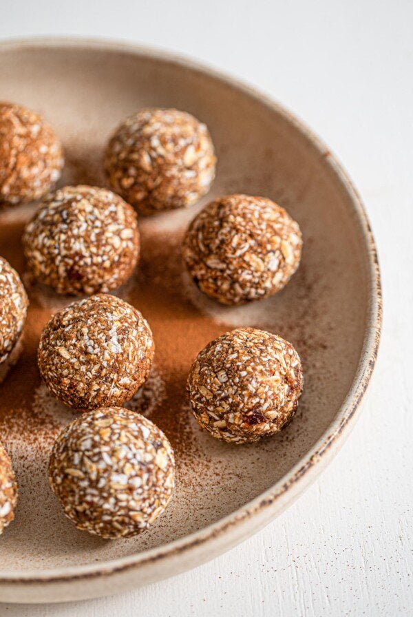 Plate of oatmeal energy balls sprinkled with cinnamon.