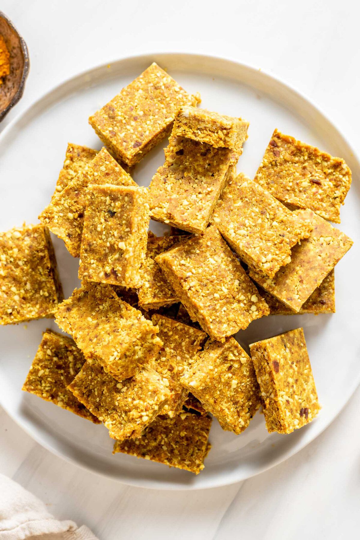 Small energy bars piled up on a white plate.