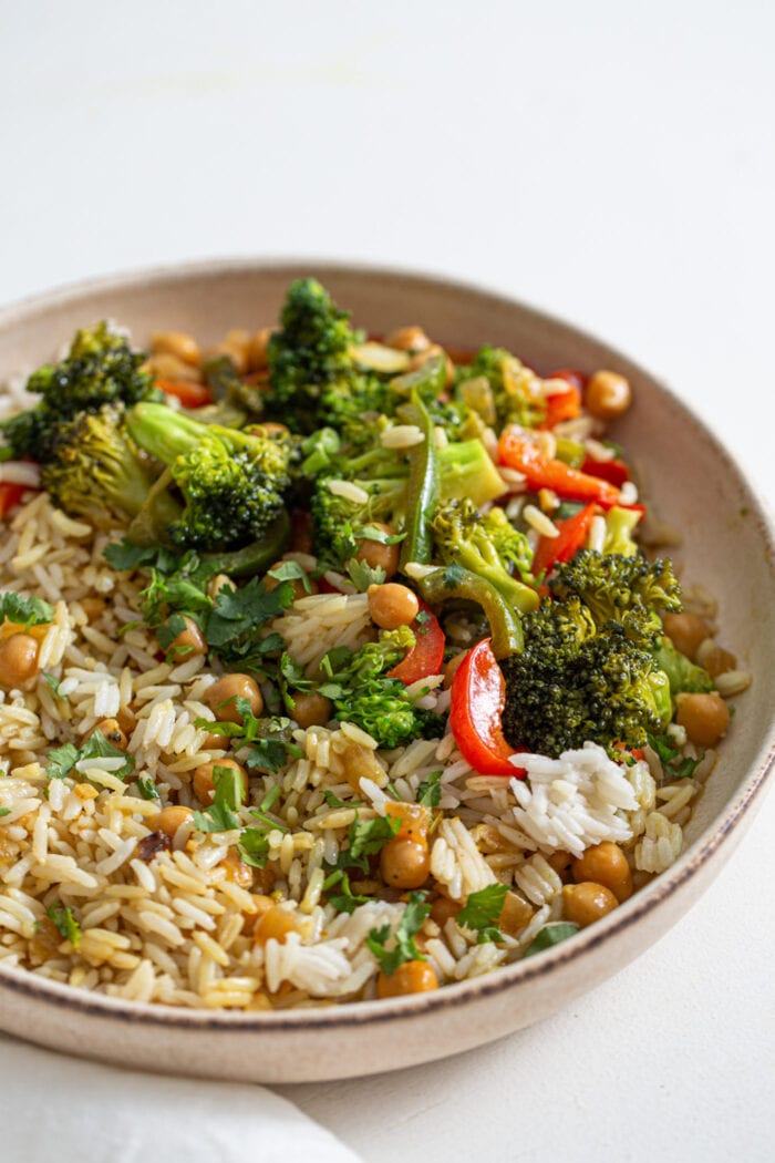 Bowl of rice, vegetables and chickpeas in a curry sauce.
