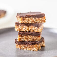 Stack of 4 chocolate coated cashew bars on a plate.