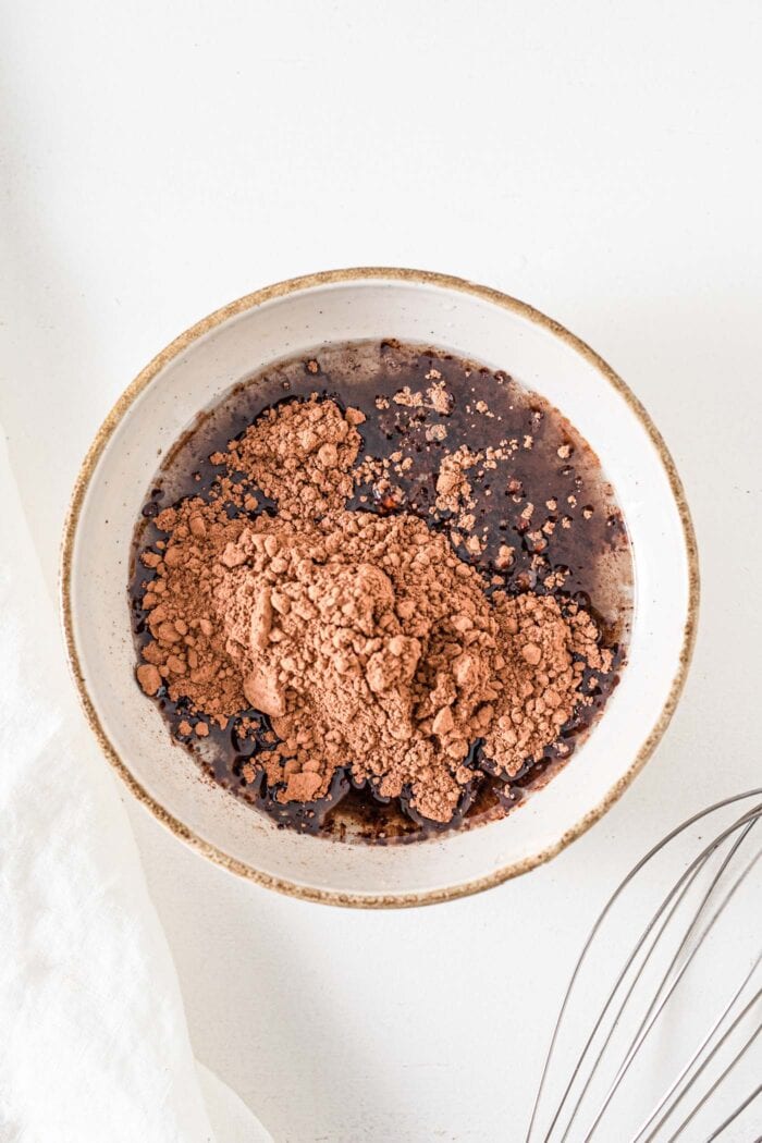 Cocoa powder, maple syrup and coconut oil mixed together in a small bowl.