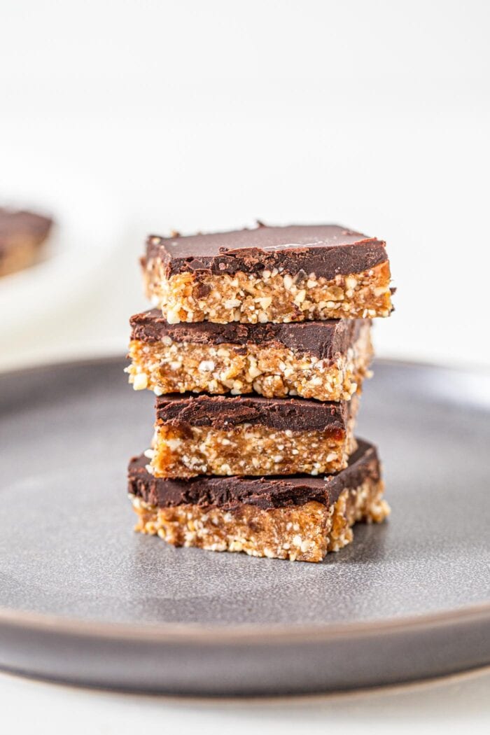 Stack of 6 chocolate coated cashew bars on a plate.