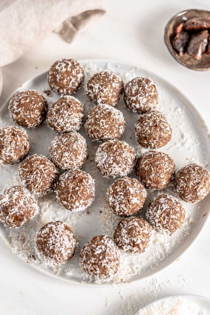 Overhead view of a plate of energy balls rolled in coconut.