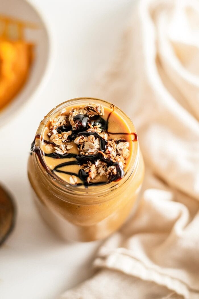 Overhead view of a smoothie topped with cookie dough and a drizzle of molasses.