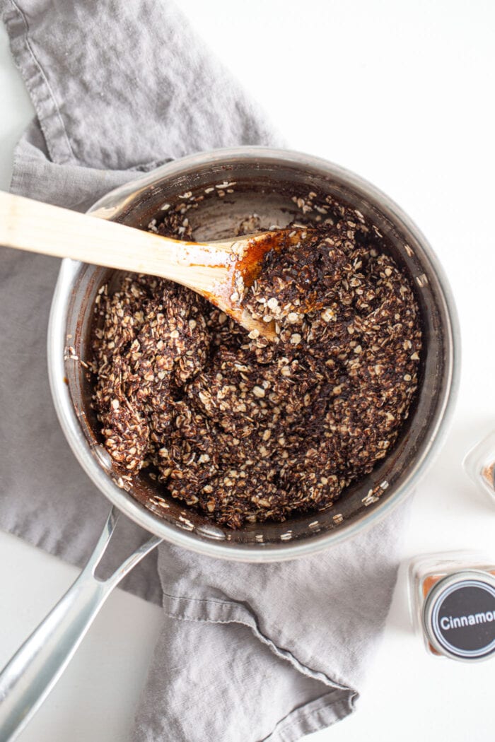 Chocolate oat mixture in a saucepan. Spoon rests in pan.