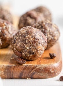 Close up of a chocolate chip energy ball on a cutting board. More balls in background.