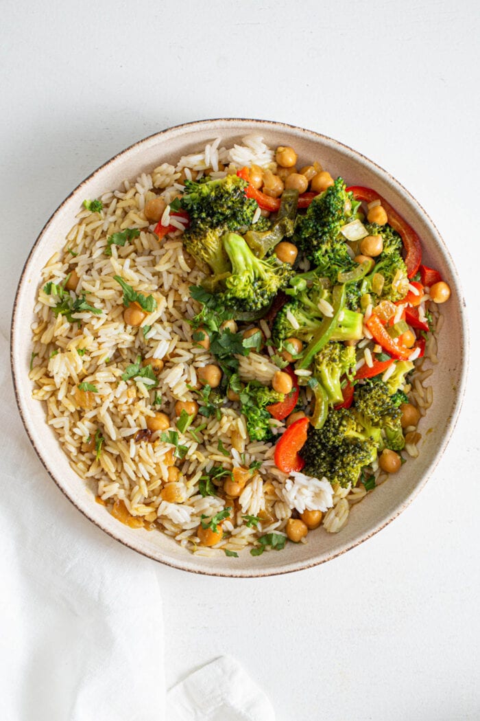 Overhead view of a bowl of rice with chickpeas and vegetables.
