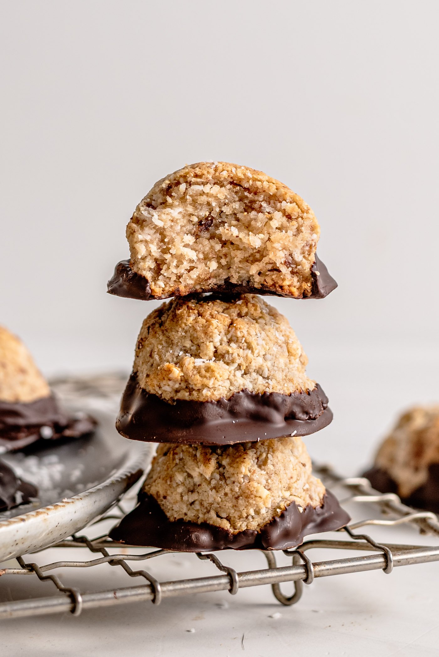 Stack of 3 coconut macaroons sitting on a cooling rack.